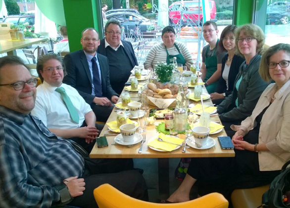 Bundestagsabgeordnete gemeinsam, die vor der Kamera schauen am Frühstückstisch